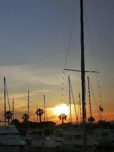 a group of boats docked in a harbor with the sunset at LOEMZI in Le Barcarès