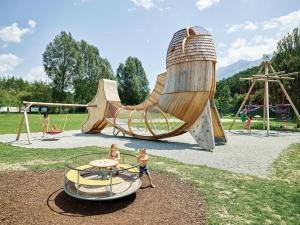two children standing in a playground with a slide at Carina's Apartment in Obsteig
