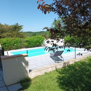 a swimming pool with a chair next to a fence at Les pieds en éventail in Lignairolles