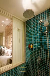 a bathroom with a green tiled wall with a shower at Villa Donna in Dona Paula