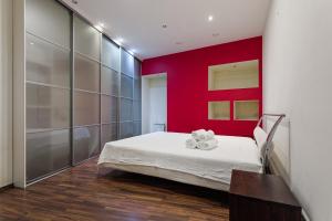um quarto com uma parede vermelha e uma cama branca em Rataskaevu 6 Apartment em Talin
