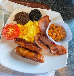 a plate of food with sausages eggs rice and beans at Whitestrand B&B in Malin Head