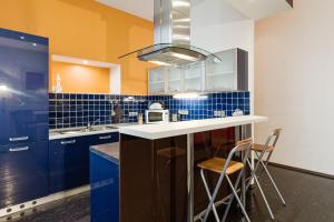 uma cozinha com armários azuis e um balcão com bancos em Rataskaevu 6 Apartment em Talin