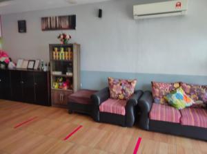 a living room with two chairs and a book shelf at Hotel Star Inn in Teluk Intan