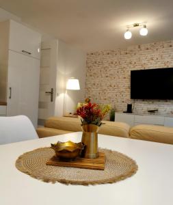 a table with a vase of flowers in a living room at PARKIDYLLE (Familien Apartment, 3 Zimmer,2 Schlafzimmer,Balkon) in Świnoujście