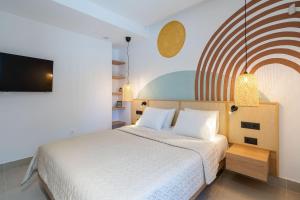 Schlafzimmer mit einem Bett und einem Flachbild-TV in der Unterkunft KoNoSo Luxury Apartments in Iraklio