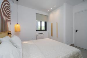 Un dormitorio con una cama blanca y una ventana. en KoNoSo Luxury Apartments, en Heraclión 22 fotos más