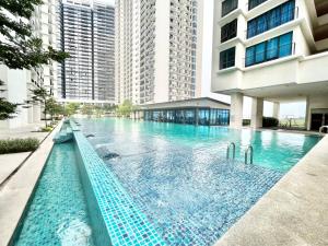 a swimming pool in the middle of a building with tall buildings at A 1-4 pax Cozy Studio TV Box Pool 100mps Wifi 3 bed Trefoil Setia Alam in Setia Alam