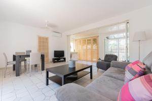 a living room with a couch and a table at MAISON COSY avec petite piscine in Six-Fours-les-Plages