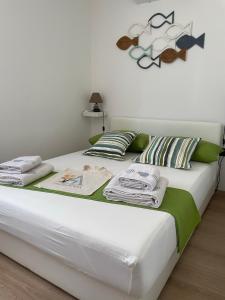 een slaapkamer met een bed met handdoeken erop bij Residence4a-Appartamento Bianco in Ravni