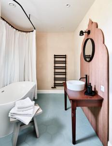 a bathroom with a white tub and a sink and a bath tub at Zámek Žďár in Žďár nad Sázavou