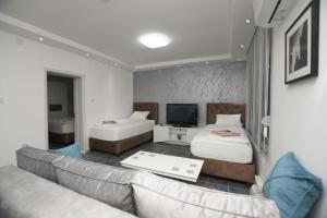 a living room with two beds and a couch at Relax Apartmani Rooms in Kladovo