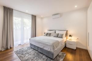 a bedroom with a bed and a large window at Apartment FORTUNA in Split