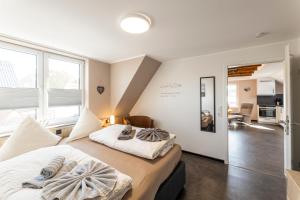 1 dormitorio con 2 camas y toallas. en Sommerwind Borkum Alfonso Wohnung 3 - Urlaub mit Hund, en Borkum