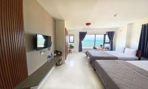 a hotel room with two beds and a flat screen tv at Thiên Hải 2 Hotel in Quy Nhon