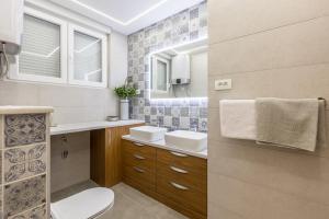 a bathroom with a toilet and a sink and a mirror at Apartment FORTUNA in Split