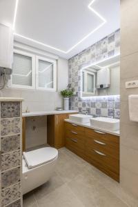 a bathroom with two sinks and a toilet in it at Apartment FORTUNA in Split