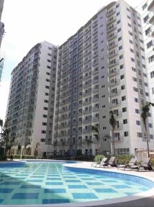 a large apartment building with a large swimming pool at 1BR unit in South Residence Las Pinas with Wifi & Netflix in Manila