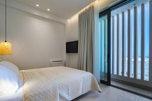 a bedroom with a bed and a large window at KoNoSo Luxury Apartments in Heraklio Town