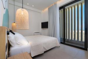 a bedroom with a white bed and a large window at KoNoSo Luxury Apartments in Heraklio Town