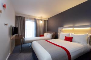 a hotel room with two beds and a television at Holiday Inn Express Cheltenham Town Centre, an IHG Hotel in Cheltenham