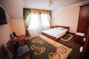ein Schlafzimmer mit einem Bett und einem großen Fenster in der Unterkunft Братіслава Тернопіль in Petrikov