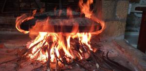 a fire is burning in a brick oven at Villa Themistokli in Korçë