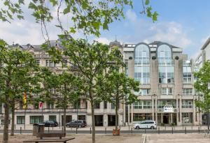 um grande edifício com árvores em frente em Select Hotel Wiesbaden City em Wiesbaden