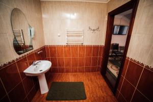ein Bad mit einem Waschbecken und einem Spiegel in der Unterkunft Братіслава Тернопіль in Petrikov