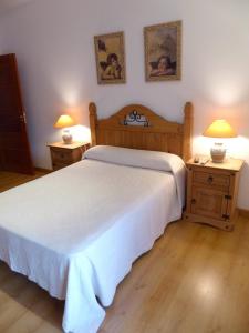 a bedroom with a white bed and two night stands at Casa La Tortola in Vitigudino