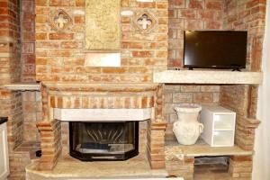 a brick wall with a fireplace and a tv at Agriturismo le Fontanelle da Valente in Montichiari