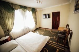 una camera d'albergo con letto e finestra di Братіслава Тернопіль a Petrikov