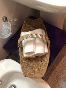 ein Korb mit Handtüchern neben einem Waschbecken in der Unterkunft Tender in Tirrenia