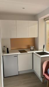 kuchnia z białymi szafkami i zlewem w obiekcie Torremolinos,estudio junto al mar en La Carihuela w mieście Torremolinos +7 zdjęć