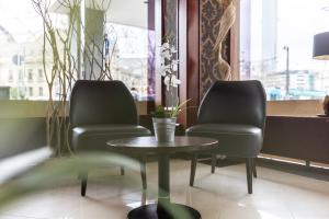 2 sillas y una mesa en una sala de espera en Novum Hotel Continental Frankfurt, en Frankfurt