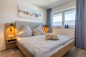 een slaapkamer met een groot bed met 2 kussens bij Fewo Backbord Haus Borkum Whg 5 in Hooksiel