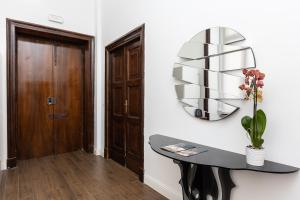 a hallway with a table and a mirror on the wall at SPA Apartment Via Barberini in Rome
