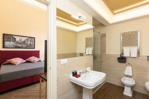 a bathroom with a sink and a toilet and a bed at SPA Apartment Via Barberini in Rome