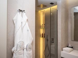 a bathroom with a shower and white towels at La Brisa Boutique Hotel in Dhërmi