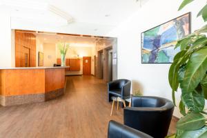 un vestíbulo de oficina con recepción y plantas en acora Leipzig Living the City - Apartments, en Leipzig