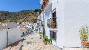 a street in positano with white buildings and potted plants at Casa Antana Frigiliana by Ruralidays in Frigiliana