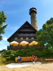 a building with a lighthouse with people sitting on a bench at Apartmány Na Valše in Sušice