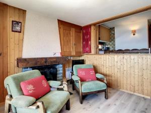 a living room with two chairs and a fireplace at Emeraude 319 in Verbier