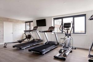 a gym with several tread machines in a room at Chi-Amore- 1 bed apartment-Bedford Town (Free Gym) in Bedford
