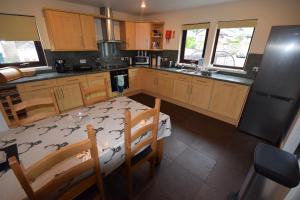 a kitchen with a table and chairs and a refrigerator at Ridgeview Villa - Partial loch view in Lochgoilhead