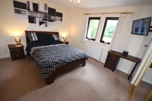 a bedroom with a black and white bed and a window at Ridgeview Villa - Partial loch view in Lochgoilhead