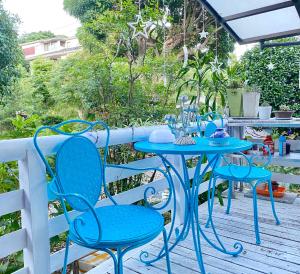 una mesa azul y sillas en una terraza en Hanamizuki Onsen Resort en Ito