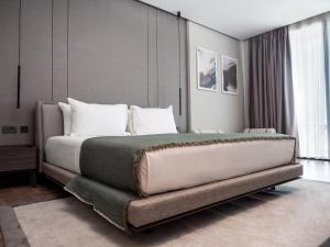 a bedroom with a large bed with white pillows at La Brisa Boutique Hotel in Dhërmi