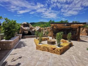 a stone patio with a fireplace with trees in it at Montenegro Royal 2 Bedroom Apartment in Bečići