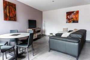 ein Wohnzimmer mit einem Sofa und einem Tisch in der Unterkunft Gîte Chez Lucile in Thann